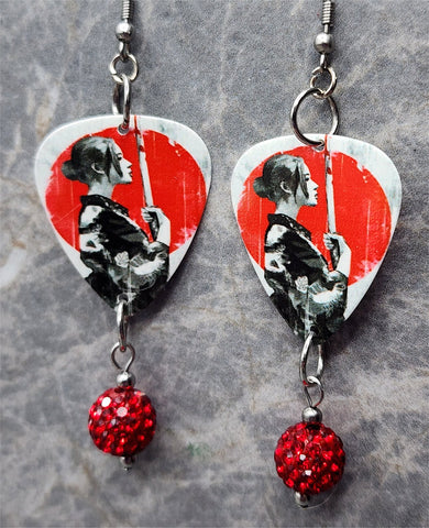Woman with Katana Guitar Pick Earrings with Red Pave Bead Dangles